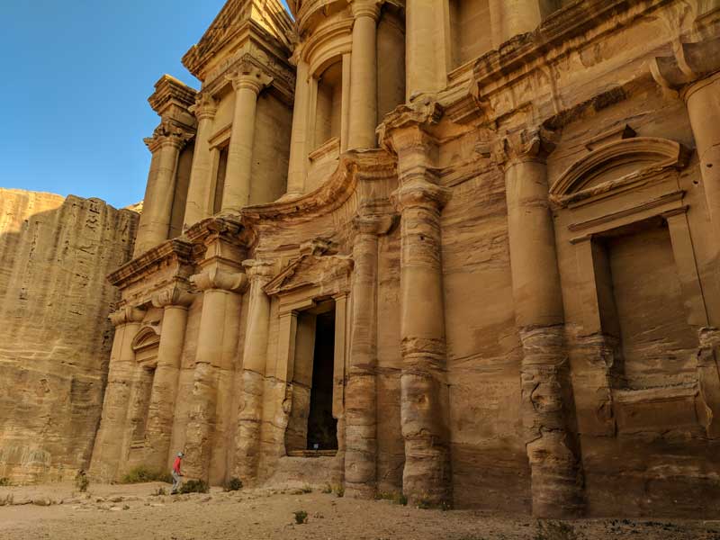 The huge cathedral of Petra with people walking in the door