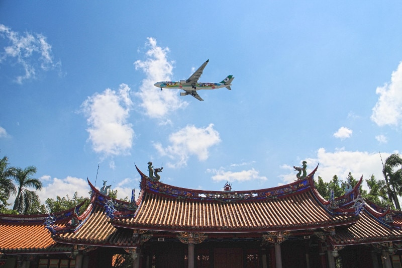 A plane flying over temple and landing in taoyuan airport