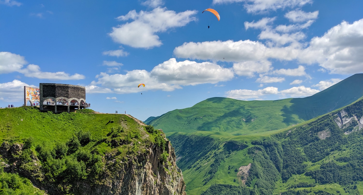 Paragliders near the Gudauri viewing point and Russia-Georgia Friendship Monument