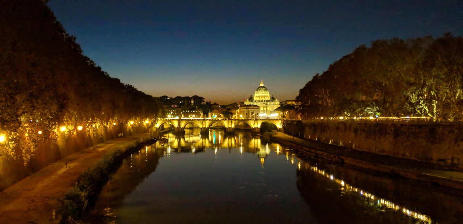 St Angelo Bridge Ponte Sant'Angelo at night with st Peters basilica in the background