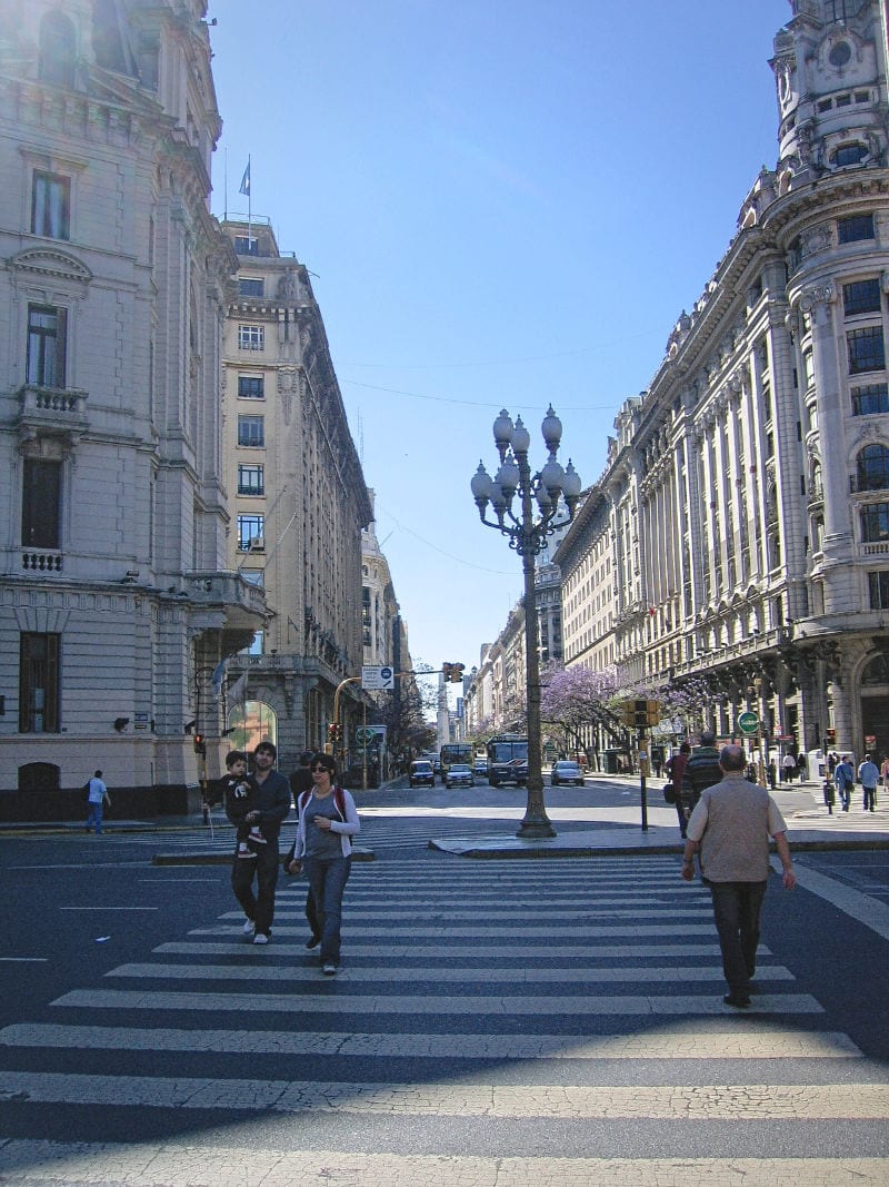 Buenos Aires street with people lamposts and cars